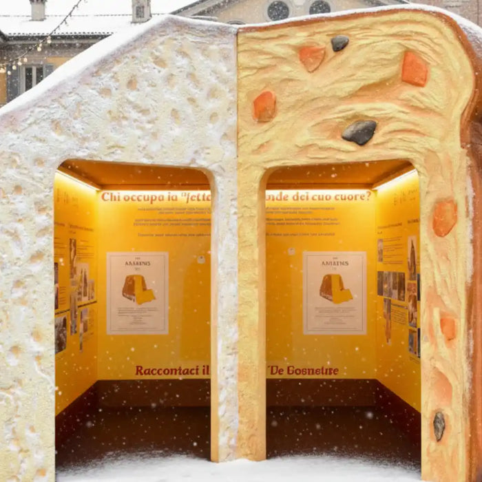 Installation festive représentant un panettone et un pandoro géants dans une place décorée pour Noël.