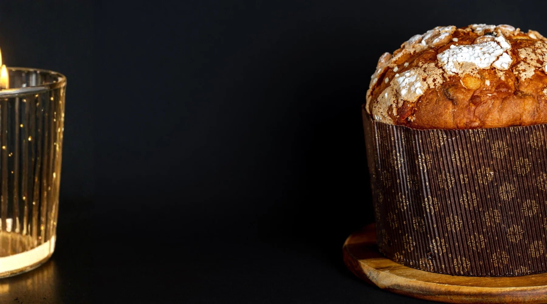Panettone artisanal italien sur fond noir, brioche traditionnelle de Noël avec croûte dorée et sucre perlé
