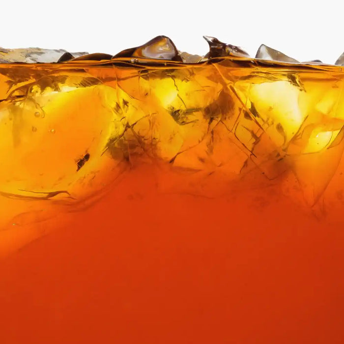 Verre d’Estathé glacé avec glaçons, couleur ambrée et ambiance rafraîchissante.