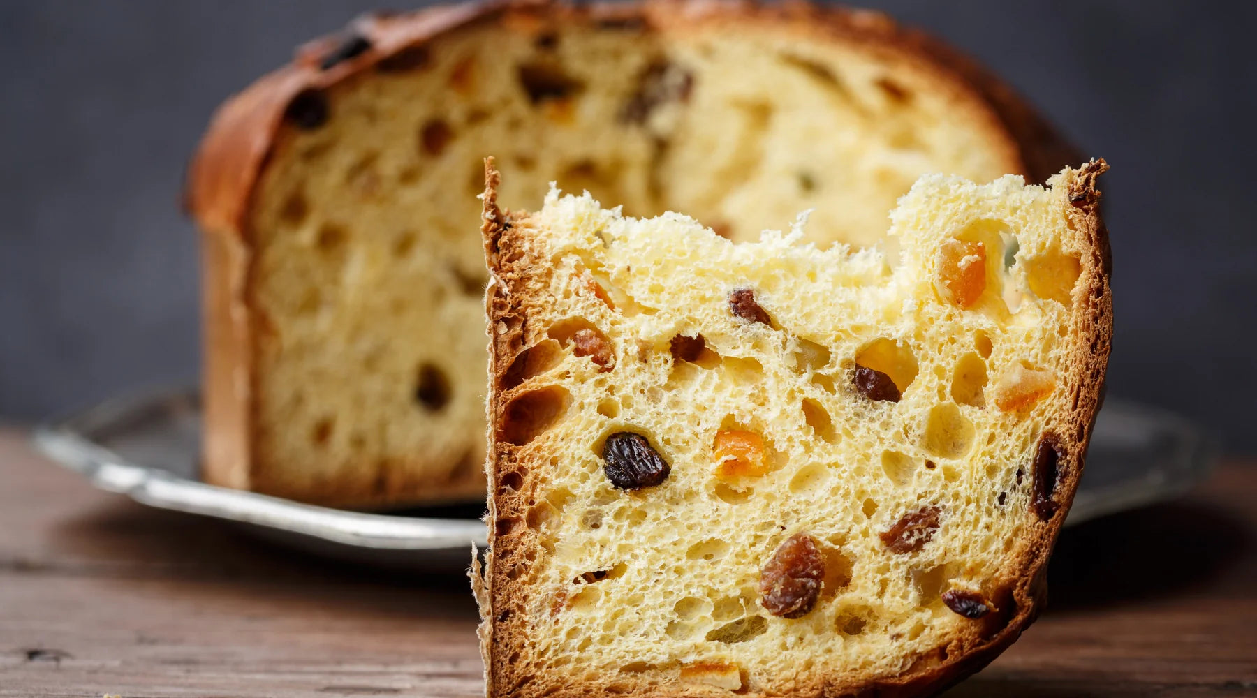 Tranche de panettone italien moelleux avec raisins secs et fruits confits, brioche traditionnelle de Milan servie sur une assiette