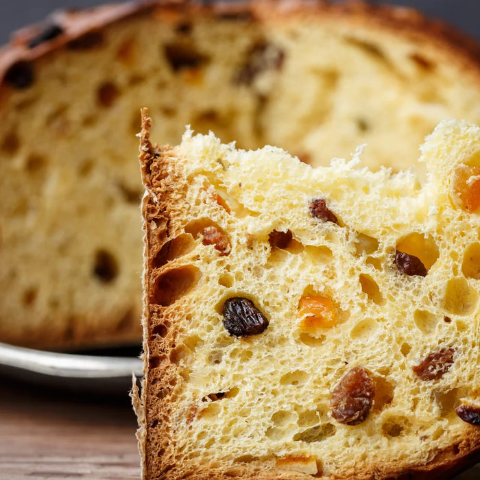 Tranche de panettone italien moelleux avec raisins secs et fruits confits, brioche traditionnelle de Milan servie sur une assiette